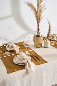 the table is set with place settings and wine glasses, napkins, and silverware