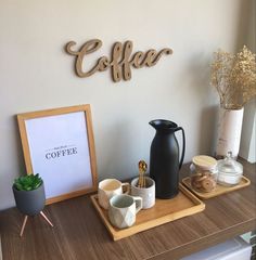 a wooden sign that says coffee on the side of a wall next to cups and mugs