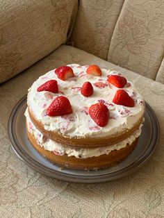 a cake with strawberries on top sitting on a plate