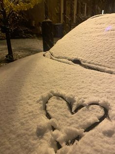 a heart drawn in the snow on top of a car