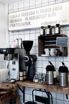 a coffee shop with various types of espresso machines on the wall and shelves