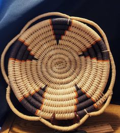 a woven basket sitting on top of a wooden table