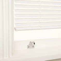 an open window with white blinds on it