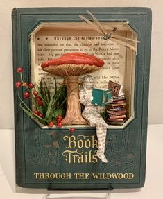 a book with a miniature doll sitting on top of it