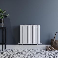 a white radiator sitting next to a plant in a room