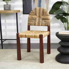 a wooden chair sitting next to a plant in a room