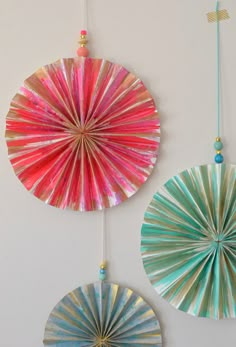 three colorful paper fans hanging on the wall