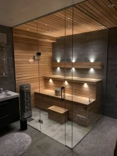 a bathroom with wooden shelves and lights on the wall, in front of a glass door