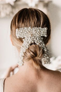 Get ready to tie the knot with the perfect bridal bow! This is the perfect hair accessory for every bride-to-be who wants to add a touch of glamour and elegance to her bridal look. This classic bow-shaped hair clip is adorned with pearls, making it a timeless and stylish accessory that you can wear to any bridal event. Dimensions: 4'' wide, 5.5'' tall Bridal Viels, Bridal Hair Half Up Half Down, Simple Bridal Hairstyle, Bridal Hair Tiara, Bridal Bow, Bachelorette Party Accessories, Pearl Hairpin, Bridal Hair Veil, Bridal Shower Outfit