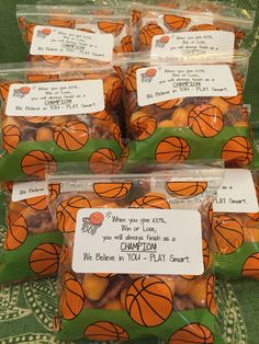 bags of basketball candies are sitting on a table with note cards attached to them