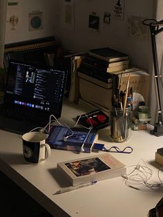 a laptop computer sitting on top of a desk next to a lamp and other items