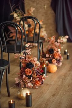 a row of chairs with flowers and candles on the floor next to each other in front of them