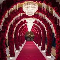 a red and white wedding aisle with roses on each side, chandelier hanging from the ceiling