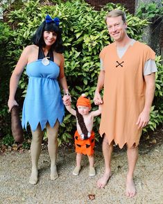 a man, woman and child dressed up in costumes standing next to each other outside