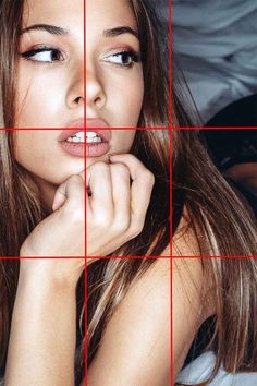 a beautiful young woman sitting in front of a red grid