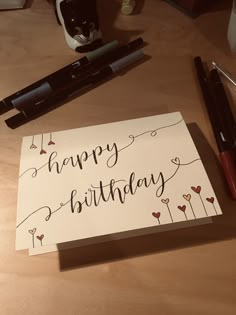 a happy birthday card sitting on top of a table next to some pens and markers