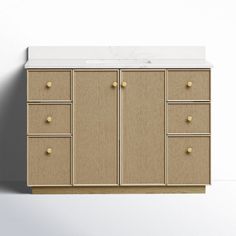 a white counter top sitting next to a cabinet with gold knobs on it's doors