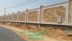 the side of a building that has been constructed with stone and stucco, in front of an empty street