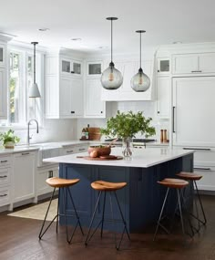 an instagram page with two chairs and a kitchen island in the middle that has three pendant lights hanging from it