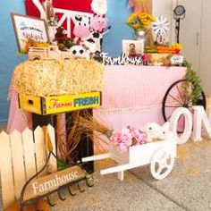 there is a farm fresh stand with hay and flowers on the table next to it