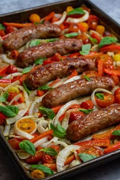 sausages and vegetables on a baking sheet ready to be cooked in the oven for dinner