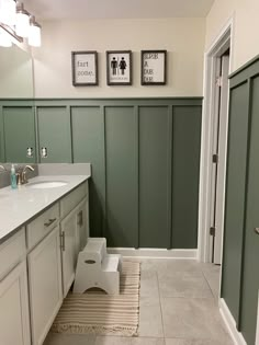 a bathroom with green walls and white cabinets