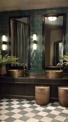 a bathroom with checkered flooring and green tiles on the walls, along with potted plants