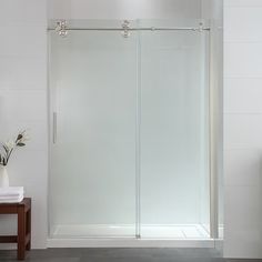 a white bathroom with a glass shower door