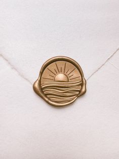 an envelope with a waxed seal on it and the sun in the sky above