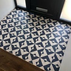 a black and white tiled floor in a room with an open door on the side