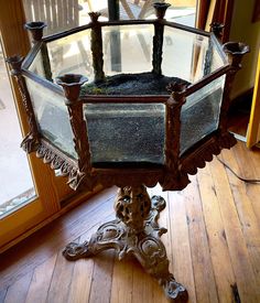 an old fashioned glass and metal stand on the floor