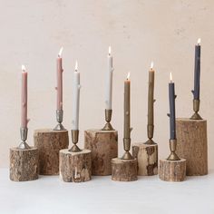 seven candles are lined up in different shapes and sizes, with one candle on top of the other