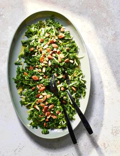 a white plate topped with greens and nuts