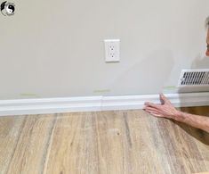 an older man laying on the floor in front of a wall heater with his hands out