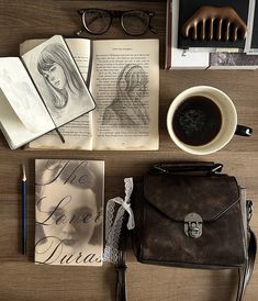 an assortment of books, glasses, and a purse on a table