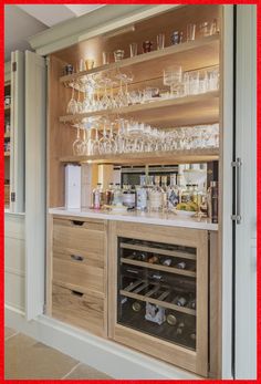 a wine bar with lots of glasses and bottles on the shelves in front of it