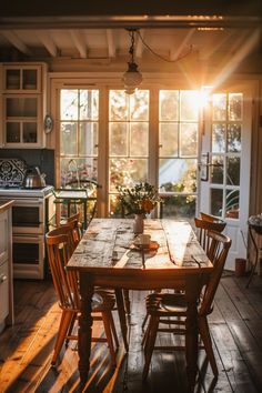 a wooden table and chairs in a room with sun shining through the windows on the wall