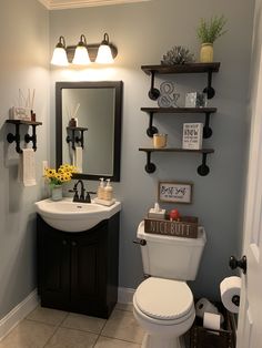 a bathroom with a toilet, sink and shelves on the wall in front of it