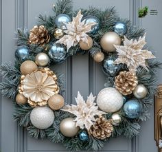 Celebrate the Holidays in style with this beautiful and delicate frosted fragrant evergreens and pine cone wreath all grown and hand-harvested from our Northern Michigan Tree Farm. Adorned with gold poinsettias, gold and teal bulbs, and an artificial dahlia, this wreath creates a warm and inviting ambiance that will greet your guests and celebrate the joy of the holidays. Its timeless beauty ensures its festivity, making it an ideal centerpiece for your front door, above the mantelpiece, or in your home's entryway as part of your holiday decor. Perfect for those who appreciate sophistication, this tasteful wreath will enhance any area of your home, from entryways to living rooms, allowing you to showcase your holiday spirit with style. Bring home this elegant door wreath and let it be a ch Michigan Trees, Pine Cone Wreath, Cone Wreath, Holiday Wreaths Christmas, Elegant Doors, Evergreen Wreath, Pine Wreath, Pinecone Wreath, Blue Wreath