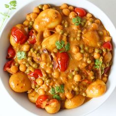 a white bowl filled with chickpeas and tomatoes