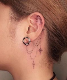 a woman's ear with tattoos on it