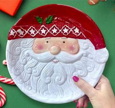 a hand holding a plate with a santa clause on it