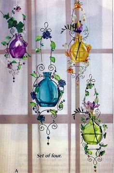 four glass vases hanging from the side of a window with vines and flowers on them