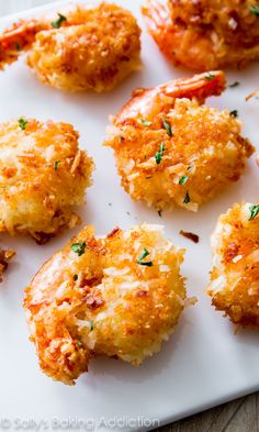 several crab cakes on a white plate with parsley sprinkled on the top