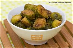 a white bowl filled with brussel sprouts on top of a wooden table