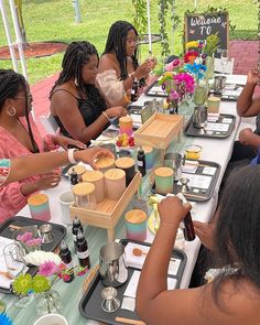 a group of women sitting at a table eating food and drinking wine in front of them