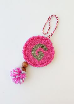 a pink ornament with a wooden bead hanging from it's side