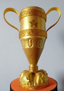 a gold trophy sitting on top of a black stand