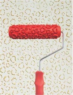 a red paint roller on a white wall