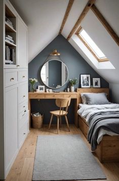 an attic bedroom with a bed, desk and mirror